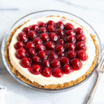 No bake cherry cheesecake dessert with cherry topping and graham cracker crust